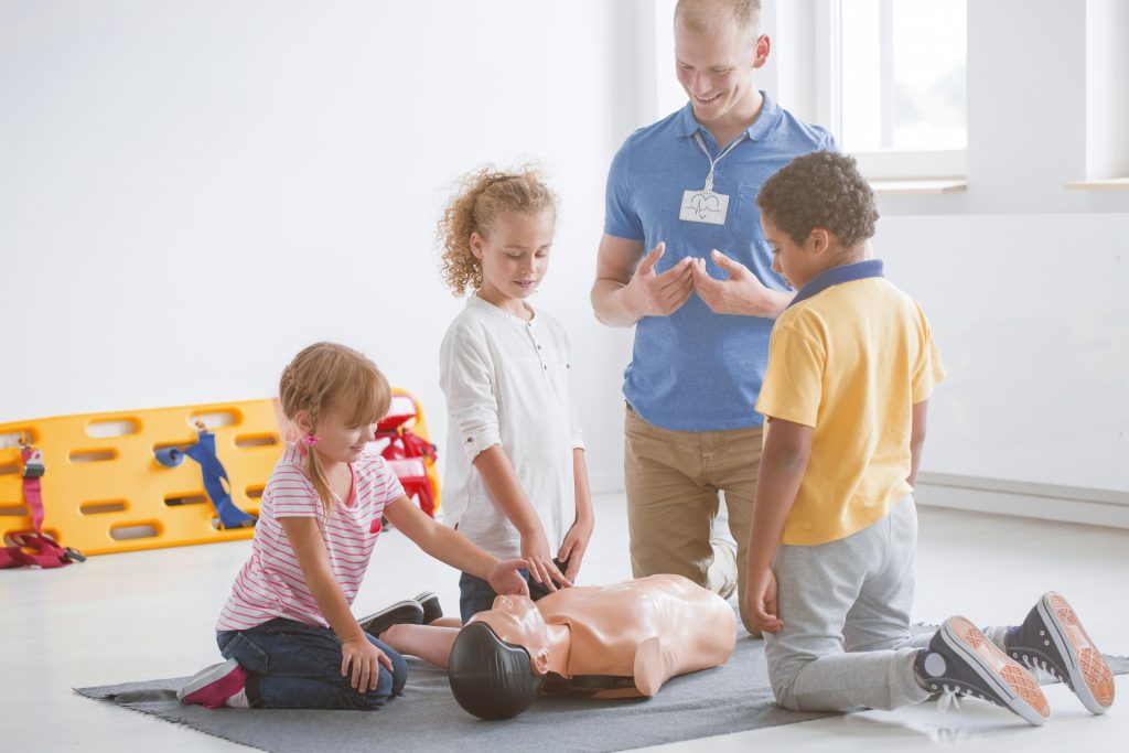 Kids practising first aid steps